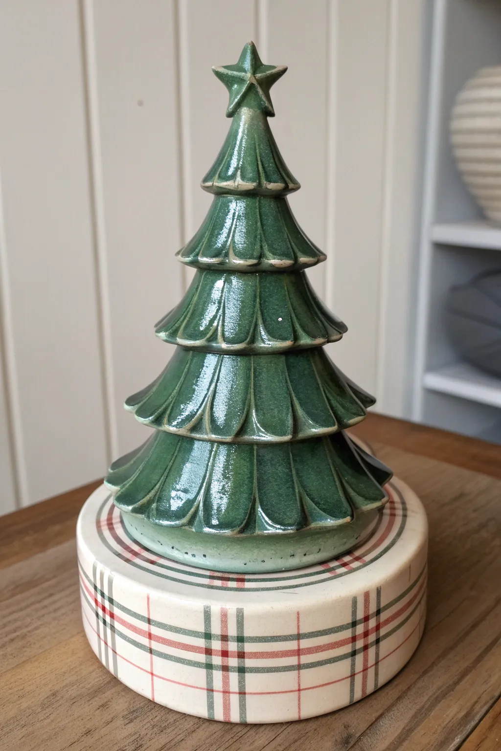 Classic plaid panels on the base add cozy contrast to a minimalist ceramic Christmas tree.