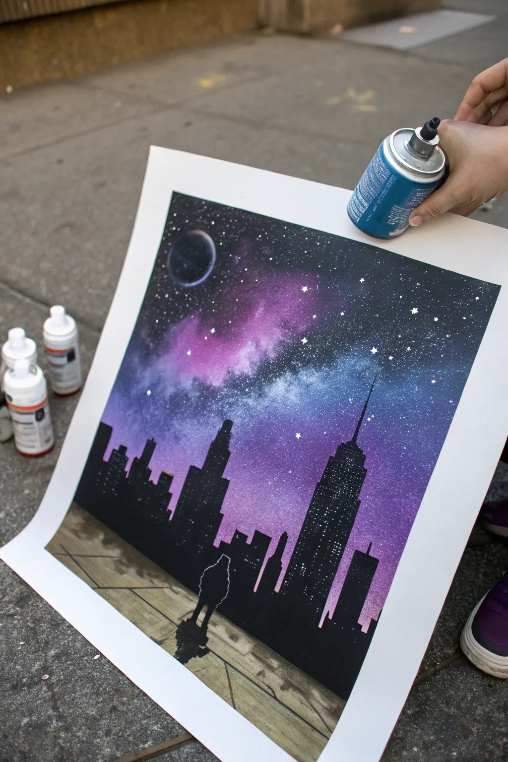 Modern spray paint skyline silhouette beneath a dreamy galaxy sky, minimalist, high-contrast.