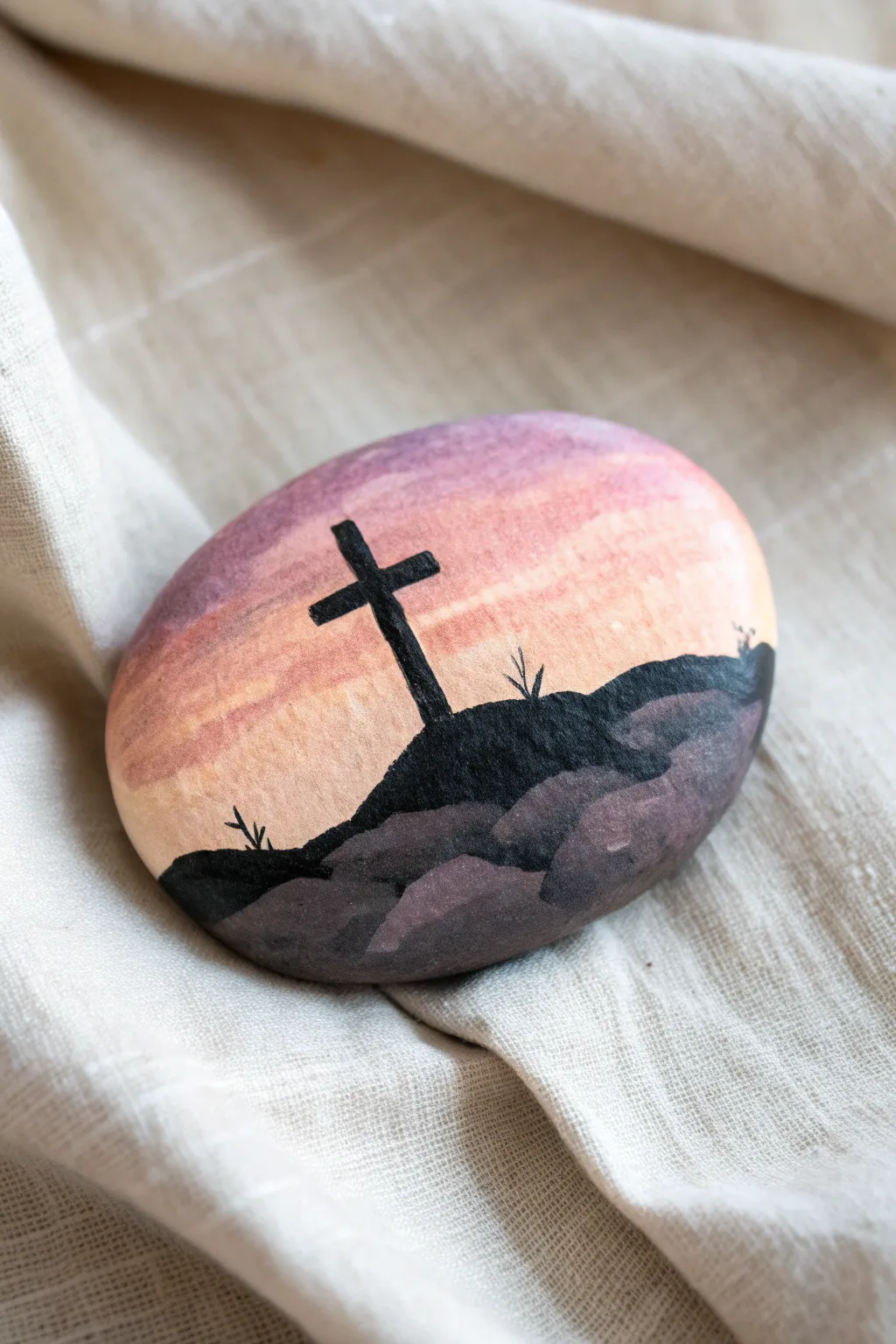 Minimal sunset painted rock with a simple cross silhouette, calm Easter craft inspiration.