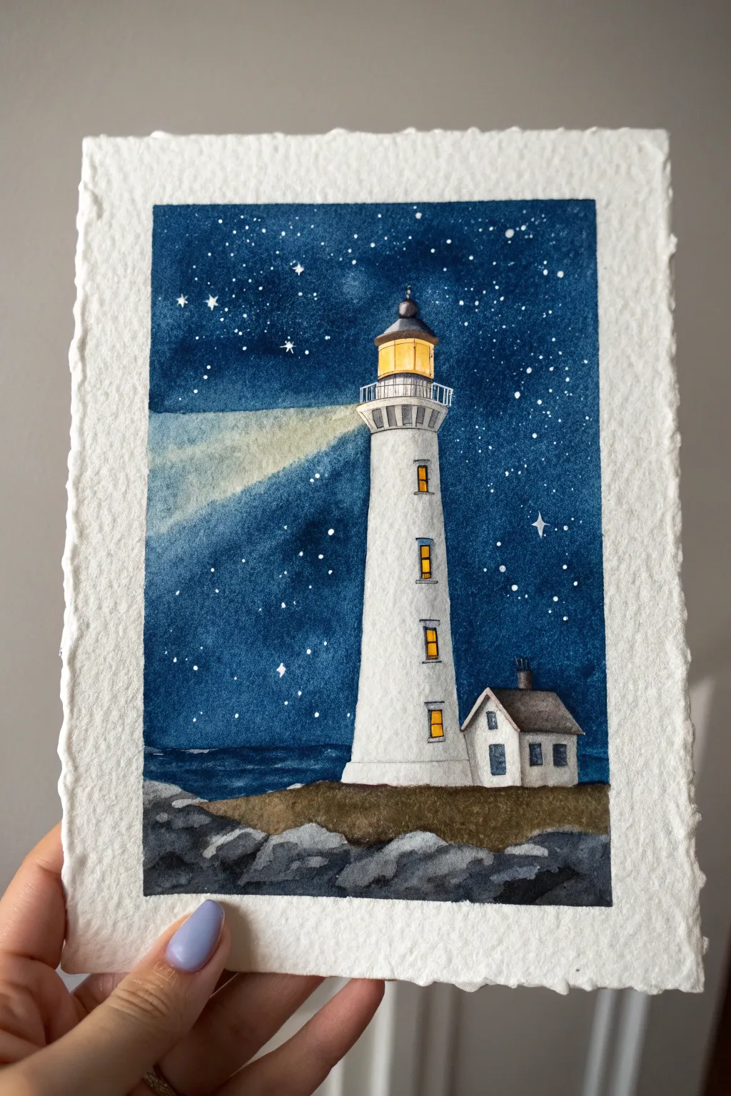 Starry night lighthouse painting idea with glowing windows, splattered stars, and a soft beam