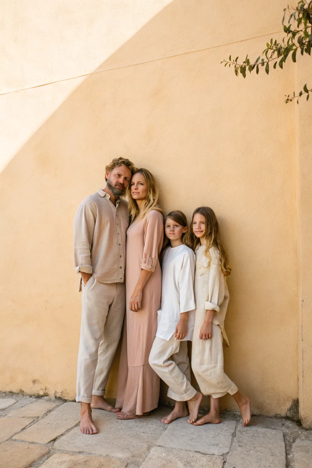 Clean wall, coordinated outfits, soft shadows, timeless family portrait inspiration.