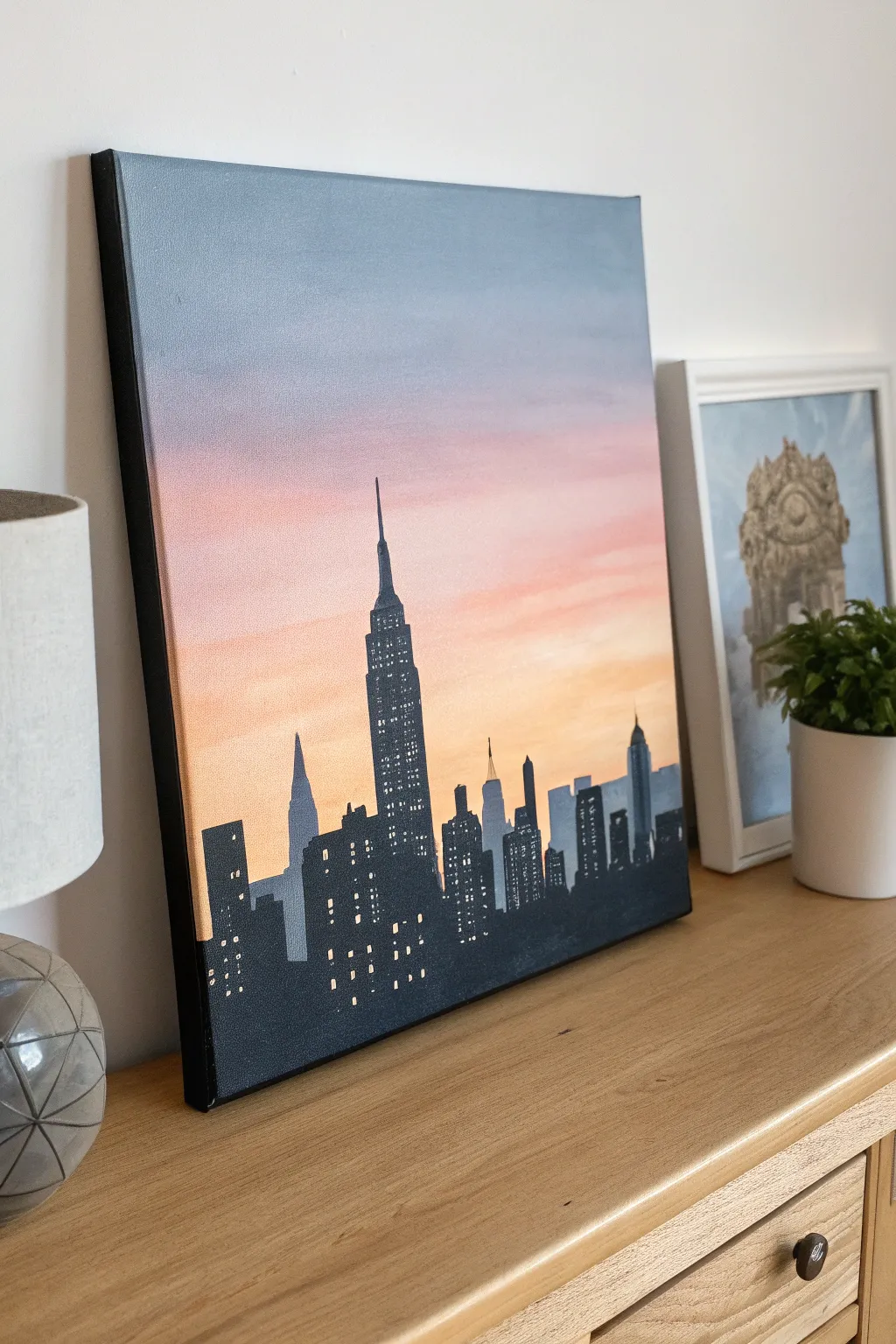 Minimal dusk skyline on medium canvas, soft gradient sky and tiny window lights for calm vibes.