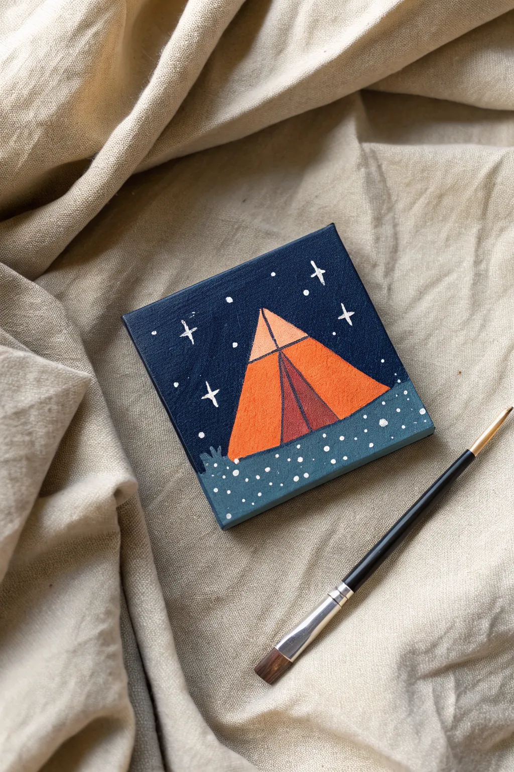 Capture the magic of a starry night with this cozy and simple campsite mini canvas painting idea.