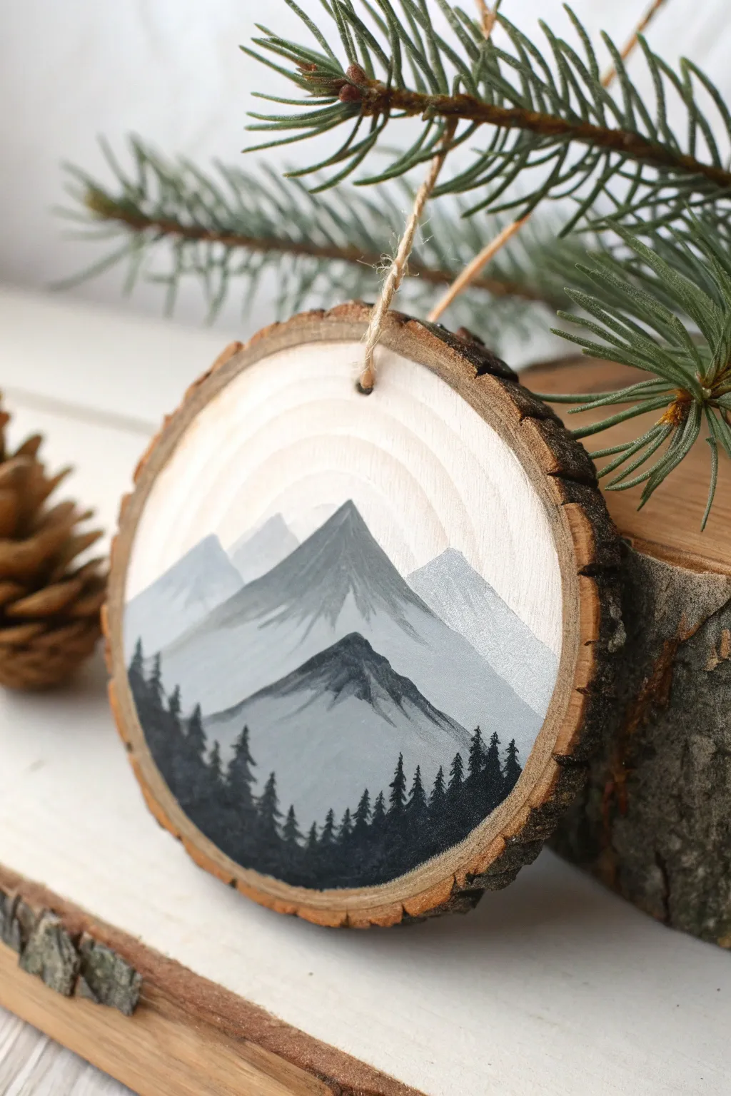 Tiny misty mountain layers painted on a wood slice ornament for cozy minimalist decor