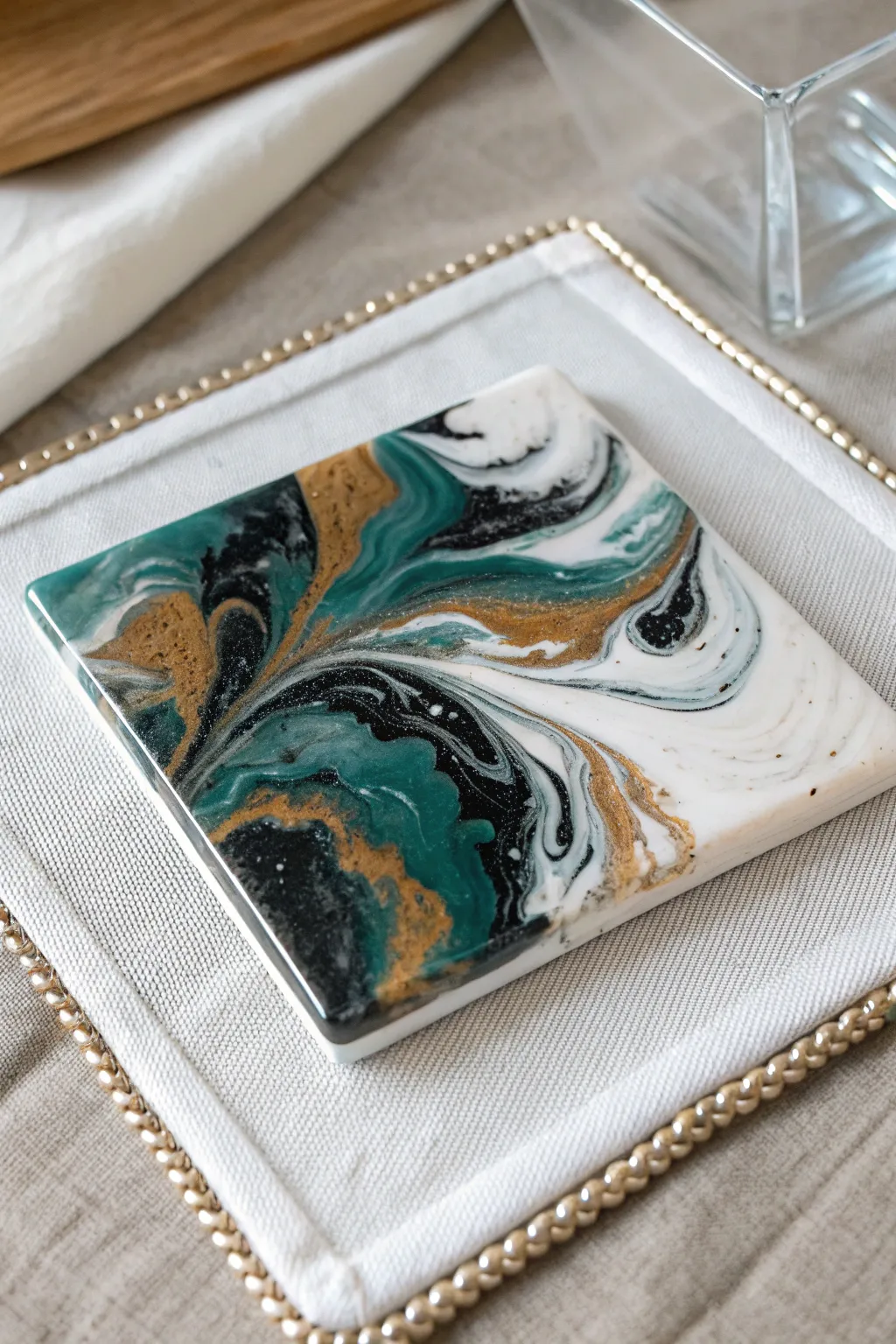 Acrylic pour coaster tile with bold swirls and glossy finish, styled on a minimal drip mat