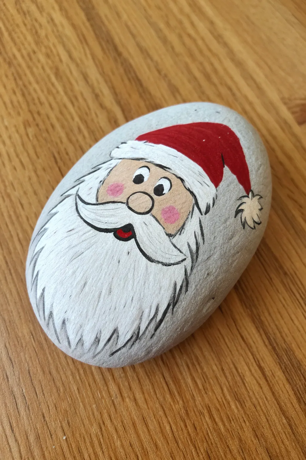Paint a cute Santa peeking over the edge on a smooth rock for cozy minimalist holiday decor