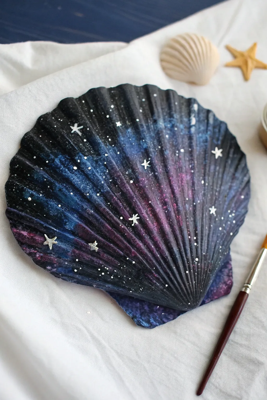 Turn a simple shell into a starry night sky with this glossy galaxy painting idea.