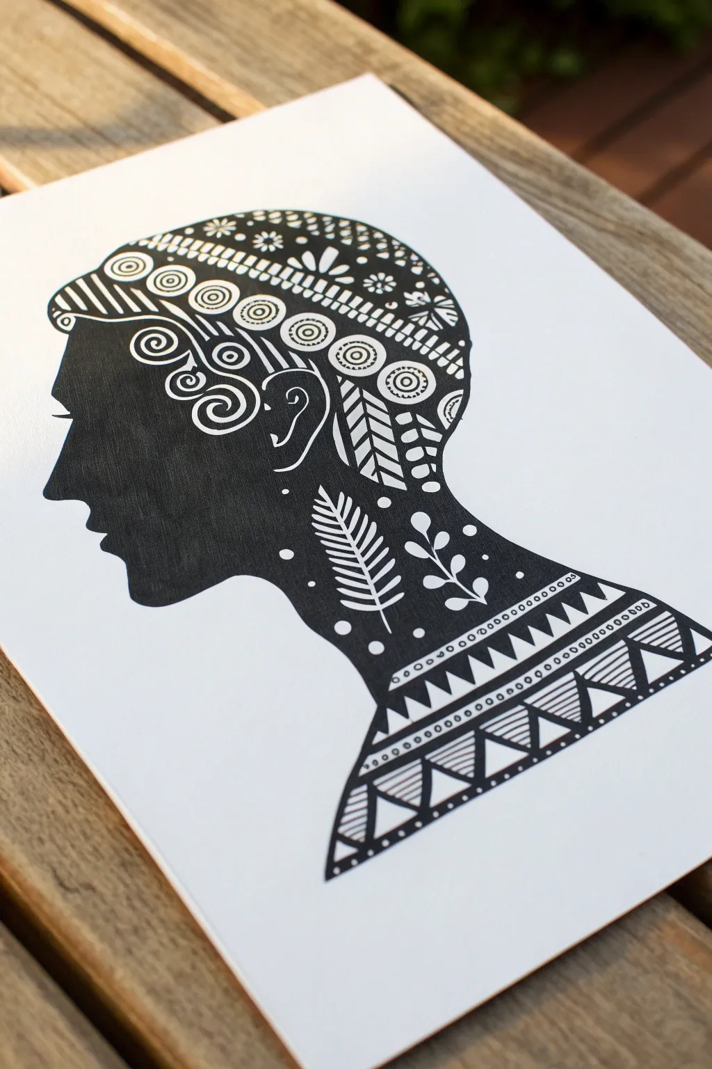 Crisp black silhouette self-portrait filled with calming hand-drawn patterns on clean white paper