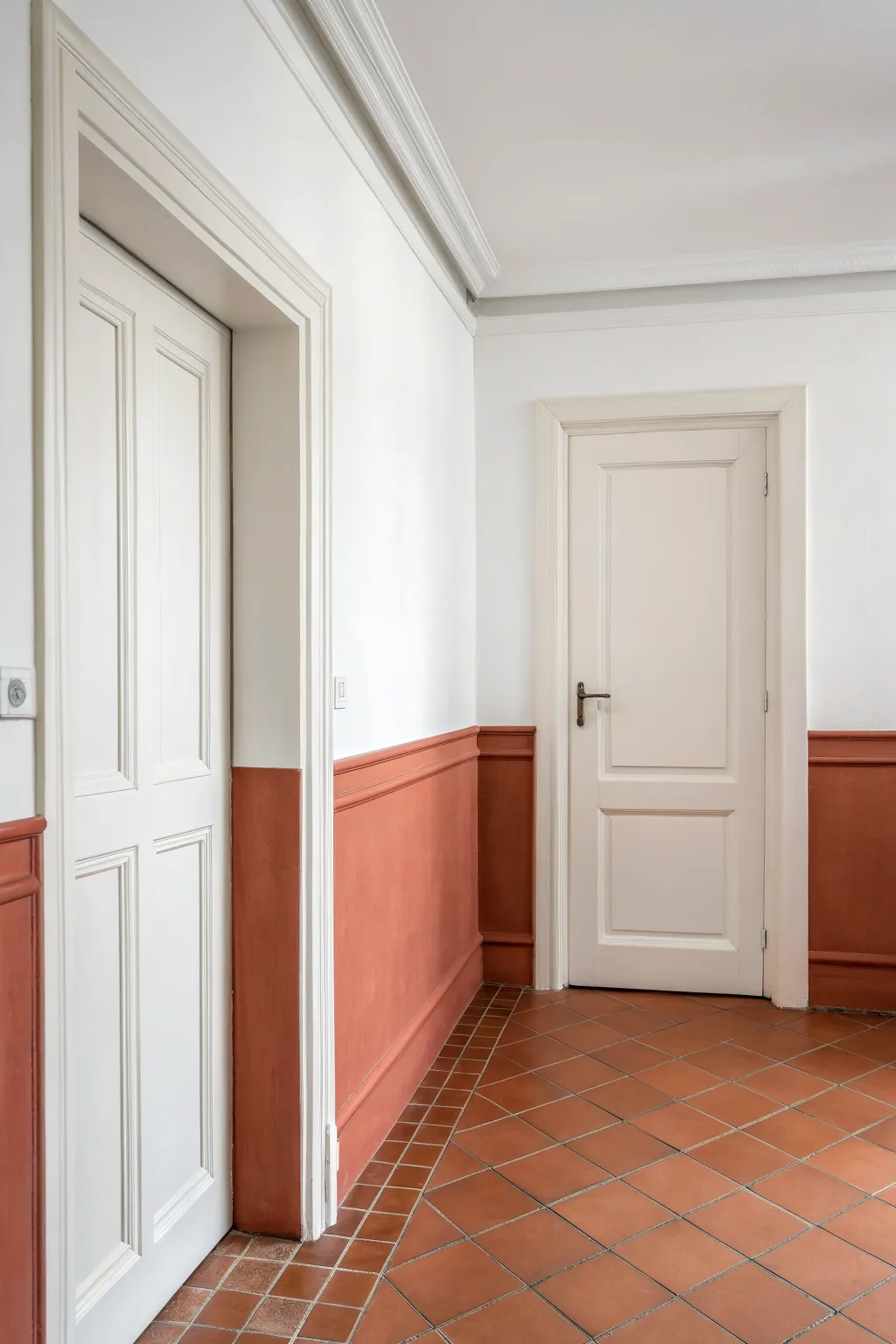 Seamless split wall where the lower hue wraps baseboards and trim for a bold, tidy block.